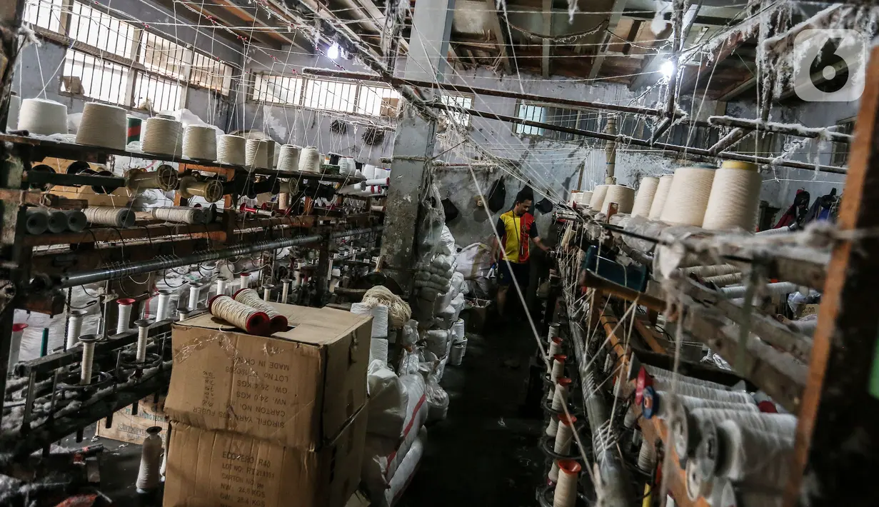 Pekerja memintal benang di Kebayoran, Jakarta, Selasa (5/7/2022). Pabrik benang yang berdiri sejak tahun 1970-an tersebut dapat memproduksi 100 kilogram benang dalam sehari dan dipasarkan ke berbagai daerah di Indonesia. (Liputan6.com/Johan Tallo)