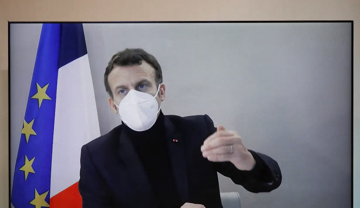 Presiden Prancis Emmanuel Macron terlihat di layar saat dia menghadiri konferensi video, meja bundar untuk Konferensi Kemanusiaan Nasional (NHC), di Kementerian Luar Negeri di Paris, Kamis (17/12/2020). Ini adalah kesekian kalinya pemimpin negara terinfeksi Covid-19. (Charles Platiau/Pool via AP)