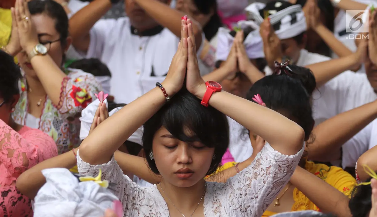 Sejumlah umat Hindu melakukan sembahyang dalam upacara Tawur Kesanga di Pura Aditya Jaya, Rawamangun, Jakarta, Jumat (16/3). Upacara ini bertujuan memohon pada Tuhan Yang Maha Esa untuk kedamaian alam dan lingkungan. (Liputan6.com/Arya Manggala)