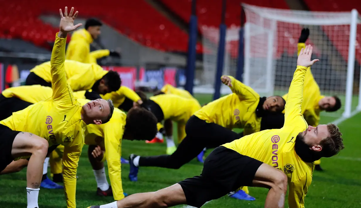 Pemain Borussia Dortmund melakukan pemanasan selama sesi latihan di Stadion Wembley di London, Inggris (12/2). Dortmund akan bertanding melawan Tottenham Hotspur pada babak 16 besar Liga Champions. (AP Photo/Frank Augstein)
