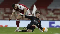 Gelandang Arsenal, Granit Xhaka (kiri) menghentikan pergerakan gelandang Slavia Praha, Jakub Hromada dalam laga leg pertama perempatfinal Liga Europa 2020/2021 di Emirates Stadium, London, Kamis (8/4/2021). Arsenal bermain imbang 1-1 dengan Slavia Praha. (AP/Alastair Grant)