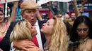 Seorang seniman berpenampilan seperti kandidat presiden AS dari Partai Republik Donald Trump melakukan aksi unjuk rasa dengan dikelilingi wanita-wanita seksi berbikini di depan Times Square, New York (25/10). (AFP Photo/Drew Angerer/Getty Images)