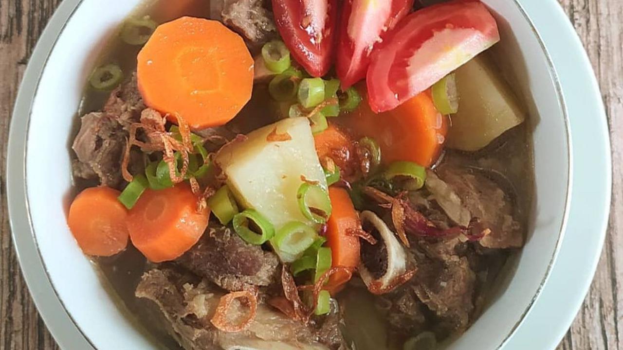 Semangkuk sop iga sapi dengan tomat dan wortel
