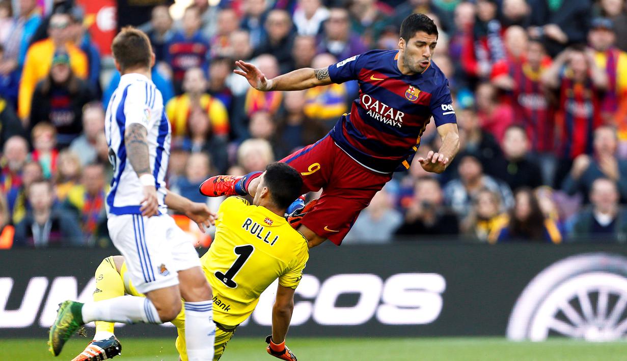 Luis Suarez berduel dengan kiper Real Sociedad, Geronimo Rulli, dalam lanjutan La Liga Spanyol di Stadion Camp Nou, Barcelona, Sabtu (28/11/2015). (EPA/Alejandro Garcia)