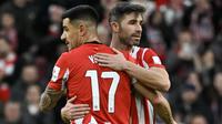 Bek Athletic Bilbao asal Spanyol #17, Yuri Berchiche (kiri), dan bek Athletic Bilbao asal Spanyol #05, Yerai Alvarez, merayakan kemenangan di akhir pertandingan sepak bola Liga Spanyol antara Athletic Club Bilbao dan Girona FC di Stadion San Mames, Bilbao, pada 8 Februari 2025. (ANDER GILLENEA/AFP)