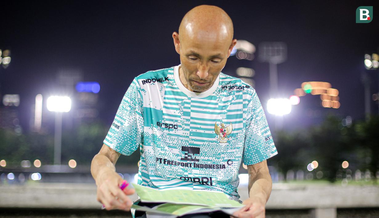 <p>Pelatih Timnas Indonesia Putri U-17, Satoru Mochizuki membuka lembaran kertas saat memimpin latihan Timnas Indonesia Putri U-17 yang berlangsung di Lapangan A Kompleks Stadion Utama Gelora Bung Karno (SUGBK), Senayan, Jakarta, Rabu (27/03/2024). Latihan tersebut merupakan bentuk persiapan untuk Piala Asia U-17 yang bergulir di Bali pada 6-19 Mei 2024. (Bola.com/Bagaskara Lazuardi)</p>