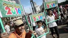 Sejumlah warga membawa papan bertulisan Happy New Year saat Car Free Day di sekitar Bunderan HI, Jakarta, Minggu (3/1/2016). Minggu pertama Tahun baru 2016 car free day ramai dipadati warga Jakarta. (Liputan6.com/Faizal Fanani)