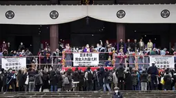 Orang-orang mencoba menangkap kacang keberuntungan yang disebarkan selama "Mame-maki", upacara melempar kacang, di kuil Buddha Zojoji, Tokyo, Jumat (3/2/2023). Selain dirayakan di rumah bersama keluarga, tradisi Mame-maki ini juga dilakukan di sekolah. Kadang kala dilaksanakan di tempat umum, seperti di pusat perbelanjaan atau di kuil.  (AP Photo/Eugene Hoshiko)