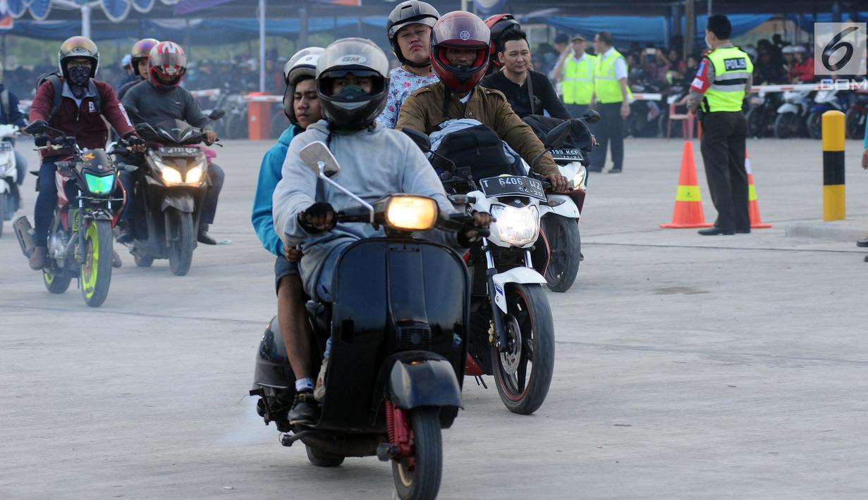 Pemudik menggunakan Vespa keluaran tahun 80 an saat masuk ke dalam kapal penyeberangan di Pelabuhan Merak, Banten, Jumat (23/6). H-2 Lebaran 2017, ribuan pemudik bermotor memadati dermaga 6 Pelabuhan Banten. (Liputan6.com/Helmi Fithriansyah)