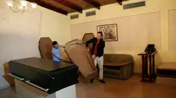 Alejandro Blanchard dan Elio Angulo sedang memindahkan peti mati dari karton di kamar mayat di Valencia, negara bagian Carabobo, Venezuela, Kamis (25/08). Akibat kelangkaan peti mati, mendorong harga pemakaman naik sekitar $ 425. (REUTERS/Marco Bello).