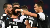 Penyerang  Juventus, Paulo Dybala (kiri) berselebrasi dengan Cristiano Ronaldo (kanan) dan rekan satu timnya setelah mencetak gol ke gawang Bologna pada pertandingan lanjutan liga Serie A Italia di stadion Renato-Dall'Ara di Bologna (22/6/2020). Juventus menang 2-0 atas Bologna. (Miguel MEDINA / AFP