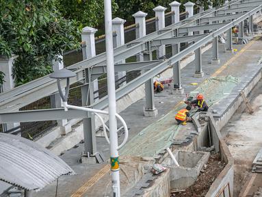 Sejumlah pekerja menyelesaikan pembangunan selter di kawasan Stasiun Palmerah, Jakarta, Selasa (2/2/2021). Penataan kawasan Stasiun Palmerah mencakup pembangunan selter untuk bus, angkot, dan ojek online. (Liputan6.com/Faizal Fanani)