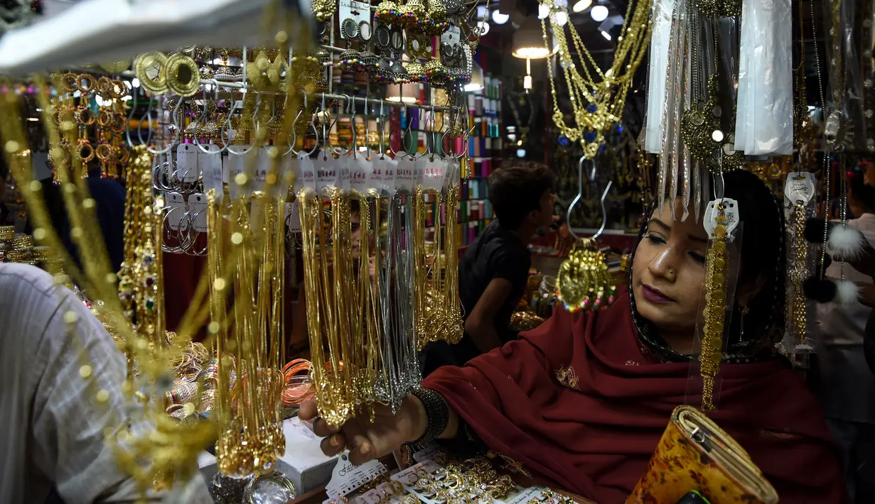 Seorang wanita Pakistan memilih perhiasan di pasar menjelang Hari Raya Idul Fitri di Karachi (3/6/2019). Umat Muslim di seluruh dunia sedang bersiap untuk merayakan Hari Raya Idul Fitri, yang menandai akhir bulan puasa Ramadan. (AFP Photo/Asif Hassan)