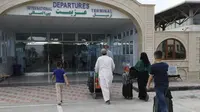 Penumpang memasuki terminal keberangkatan Bandara Internasional Hamid Karzai di Kabul, Sabtu (14/8/2021). Saat Taliban terus merangsek mengepung ibu kota Afghanistan, hanya ada satu jalan keluar bagi mereka yang melarikan diri dari perang, yaitu bandara internasional Kabul. (AP/Rahmat Gul)