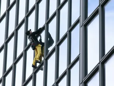 Alain Robert ketika memanjat gedung di pusat bisnis La Defense, Paris, Prancis, Senin (21/3/2016). Pria yang dijuluki 'Spiderman' ini telah memanjat lebih dari 70 gedung tertinggi di dunia. (Jacques DEMARTHON/AFP)