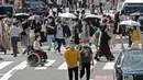 Orang-orang yang memakai masker untuk membantu melindungi diri dari penyebaran virus corona berjalan melintasi persimpangan di Tokyo, Senin (30/8/2021). Jepang masih memerangi lonjakan kasus COVID-19. (AP Photo/Koji Sasahara)