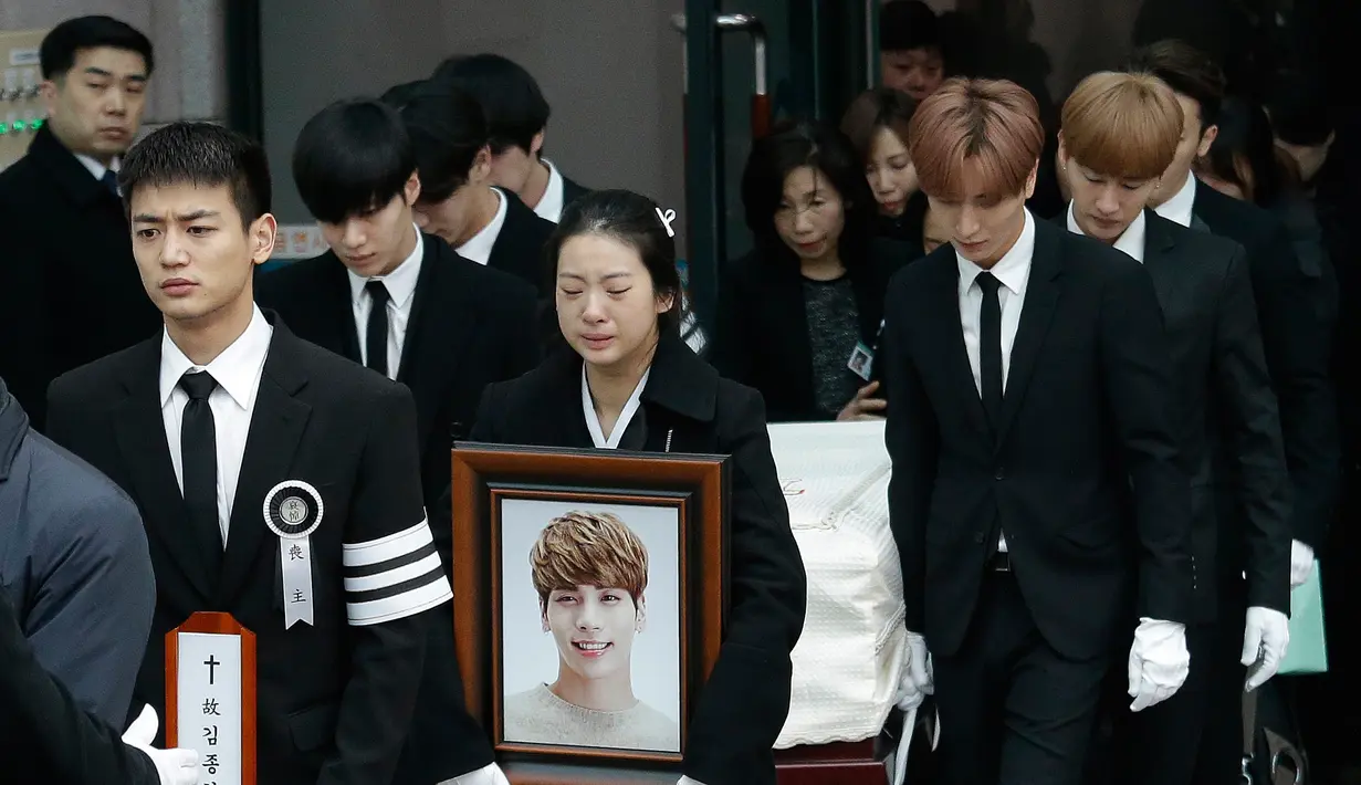Personel SHINee dan Super Junior mengangkat peti Jonghyun pada pelepasan jenazah menuju tempat pemakaman dari Asan Hospital, Seoul, Kamis (21/12). Prosesi pemakaman dipimpin kakak perempuan Jonghyun dan rekannya di SHINee, Choi Minho. (AP/Ahn Young-joon)