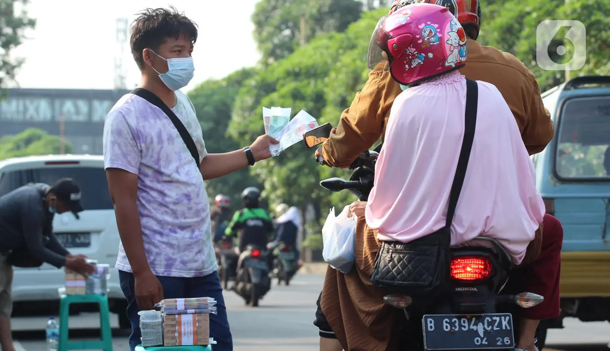 Penjual jasa penukaran uang baru menawarkan uang baru kepada pengguna Jalan Otista Raya di Karawaci, Kota Tangerang, Senin (10/5/2021). Penjual jasa penukaran uang baru musiman tersebut mulai bermunculan menjelang lebaran yang dikenakan tarif jasa sebesar 10 persen. (Liputan6.com/Angga Yuniar)