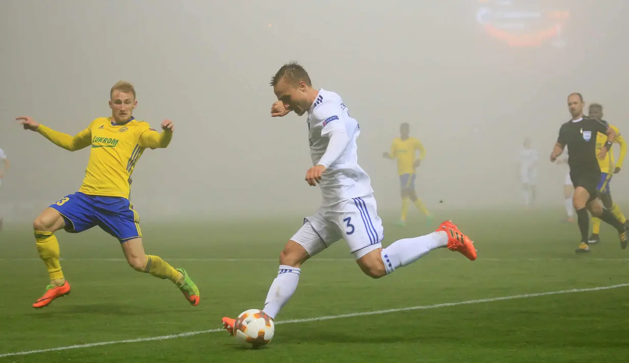 Bek FC Copenhagen, Pierre Bengtsson berusaha mengumpan bola dari kawalan gelandang FC Fastav Zlín, Milos Kopecny saat bertanding pada Grup F Liga Europa di Stadion Andruv, Ceko (19/10). Kedua klub bermain imbang 1-1. (AFP Photo/Radek Mica)
