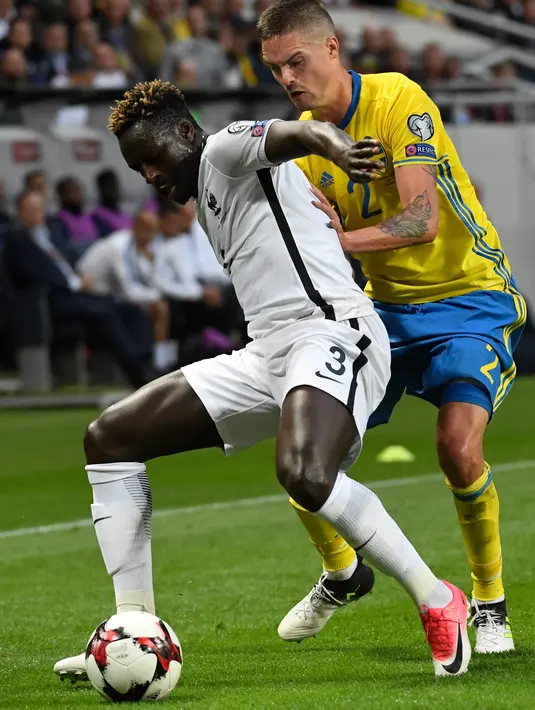 Bek Prancis, Benjamin Mendy berusaha mengontrol bola dari kawalan bek Mikael Lustig saat bertanding di kualifikasi Piala Dunia 2018 di Friends Arena, Solna, Stockholm (9/6). Swedia menang atas Prancis dengan skor 2-1. (Janerik Henriksson/TT via AP)