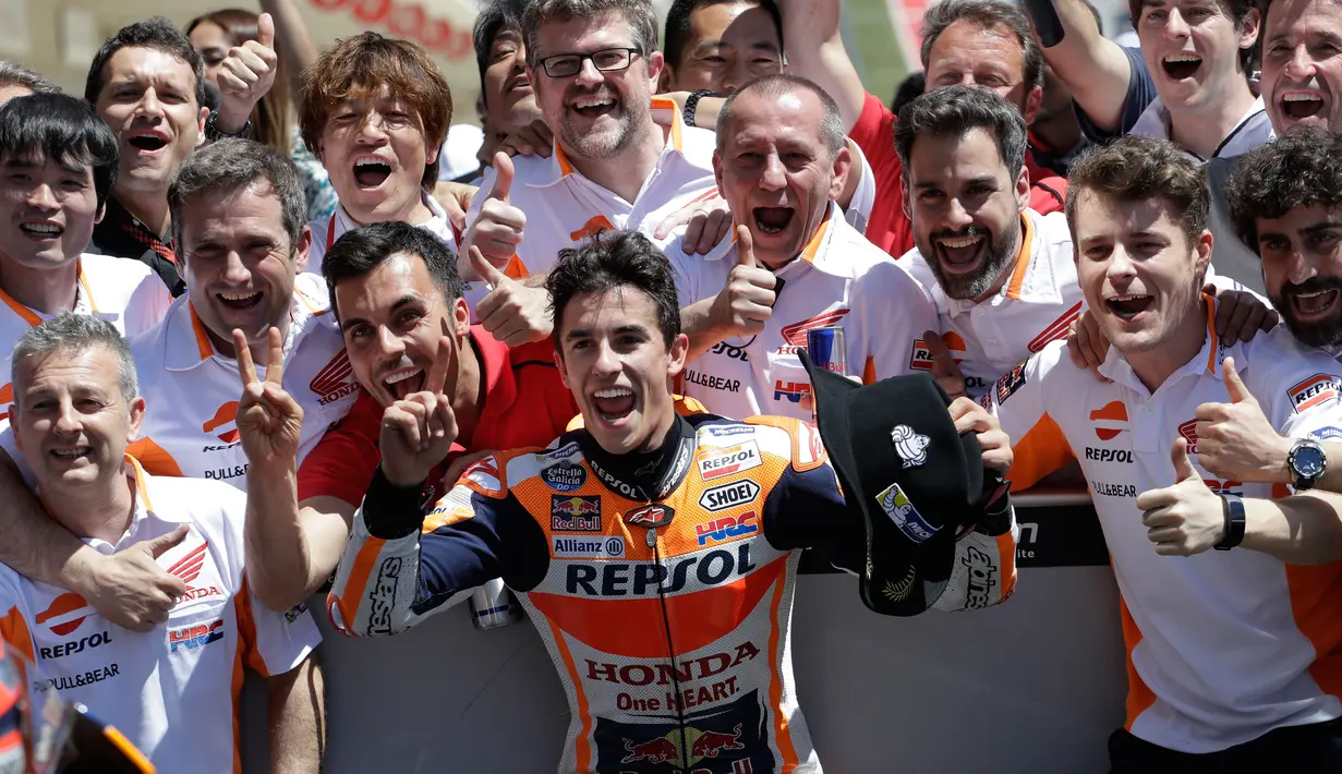 Marc Marquez berpose bersama timnya setelah berhasil finish diurutan pertama pada MotoGP Amerika di Austin, Texas, (23/4). (AP Photo/Eric Gay)