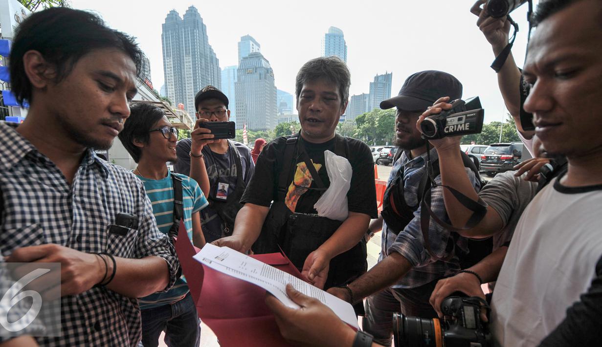 Pewarta Foto Indonesia (PFI) Lucky Pransiska didampingi tim divisi advokasi melaporkan terkait kasus penyebaran informasi palsu melalui sosial media di Polda Metro Jaya, Jakarta, Rabu (11/1). (Liputan6.com/Yoppy Renato)