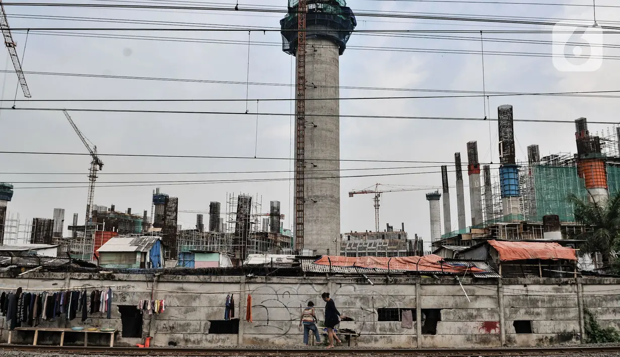 Warga berjalan melintasi pemukiman yang berada di dekat proyek pembangunan JIS atau Stadion BMW, Jakarta, Kamis (9/7/2020). Proyek stadion bertaraf internasional ini berkapasitas 80 ribu penonton. (merdeka.com/Iqbal S. Nugroho)