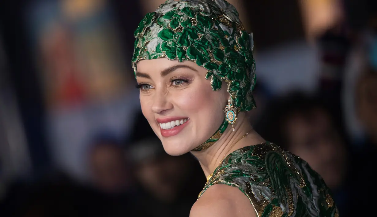 Aktris cantik Amber Heard berpose untuk fotografer setibanya menghadiri premier dunia film 'Aquaman' di London, Senin (26/11). Mantan istri aktor Johnny Depp ini datang dengan dibalut gaun couture dan hiasan kepala. (Vianney Le Caer/Invision/AP)