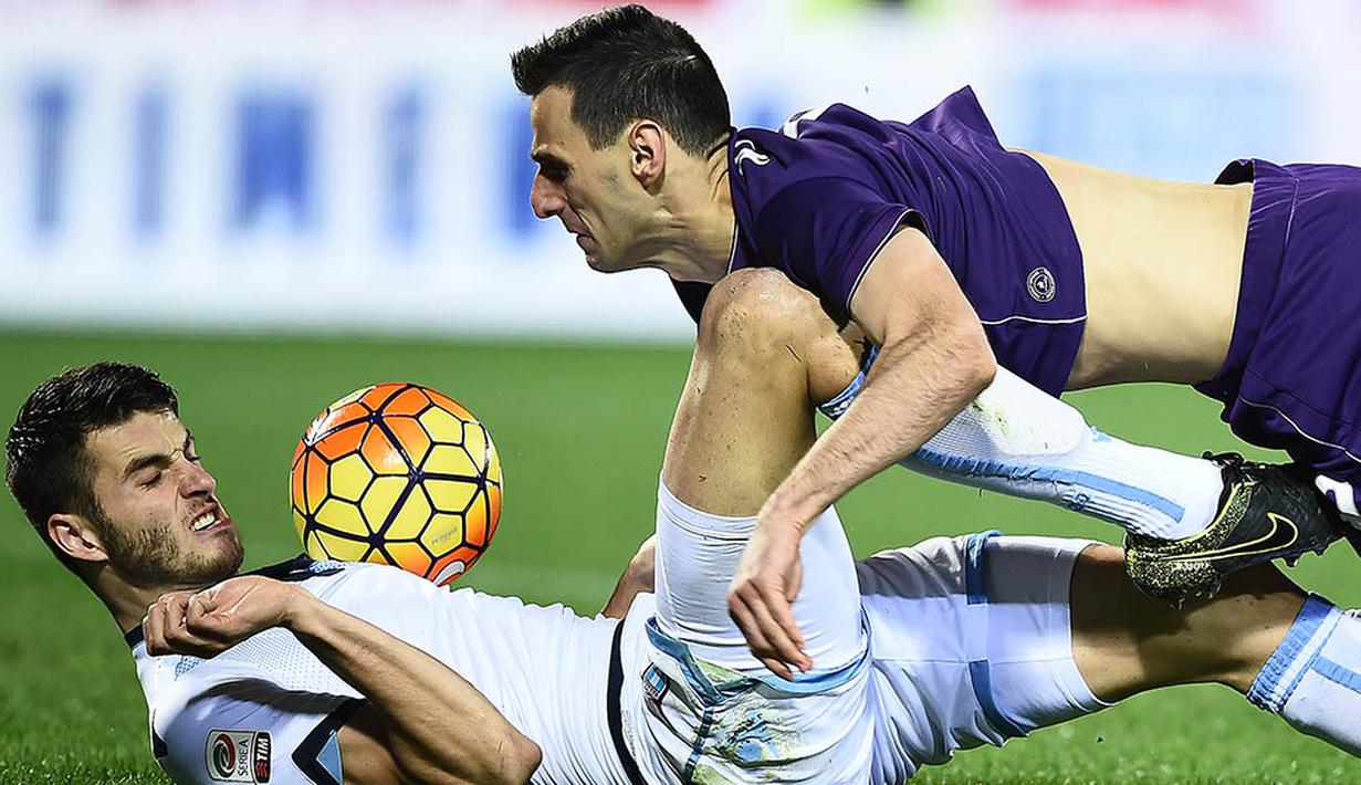 Penyerang Fiorentina, Nikola Kalini, terjatuh berebut bola dengan bek Lazio, Wesley Hoedt, pada laga Serie A di Stadion Artemio Franchi, Italia, Sabtu (9/1/2016). Lazio berhasil menang 3-1. (AFP/Filippo Monteforte)
