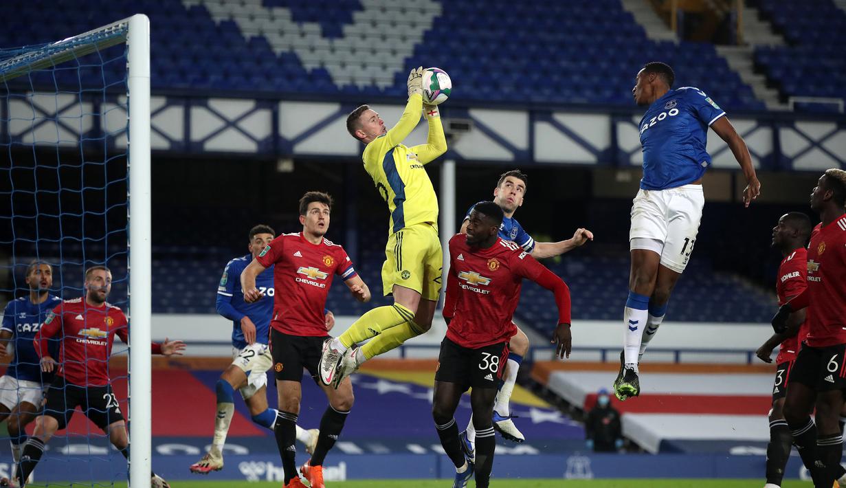 Kiper Manchester United, Dean Henderson, melompat untuk menangkap bola dari ancaman pemain Everton dalam laga perempatfinal Piala Liga Inggris Carabao Cup di Goodison park, Rabu (23/12/2020). Manchester United menang 2-0 atas Everton. (AFP/Nick Potts/Pool)