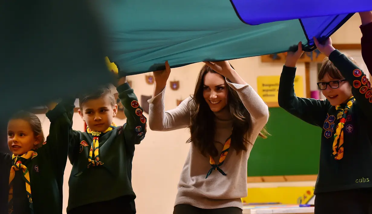 Kate Middleton ikut bermain bersama sejumlah anak-anak dalam acara Cub Scout Pack di Kings Lynn, Inggris (14/12). Kate memang dikenal sering berpartisipasi dalam acara Pramuka setiap tahunnya. (Reuters/Ben Stansall/Pool)