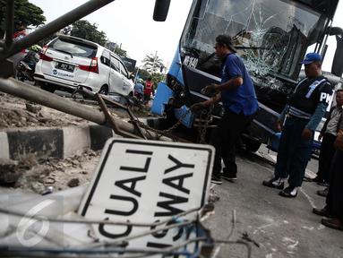 Petugas mengevakuasi bus gandeng TransJakarta yang menabrak pagar pembatas jalan, di Jalan Gunung Sahari, Jakarta, Selasa (6/9). Tak ada korban jiwa dalam insiden yang diduga lantaran sopir mengantuk tersebut. (Liputan6.com/Faizal Fanani)