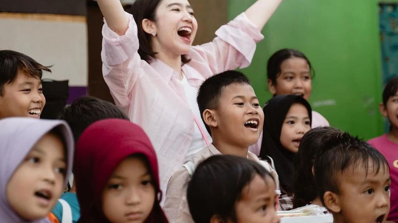 Dalam balutan blouse merah muda dan rambut pendek, mantan personel Blink itu tampil kasual sambil tersenyum bahagia.<br>