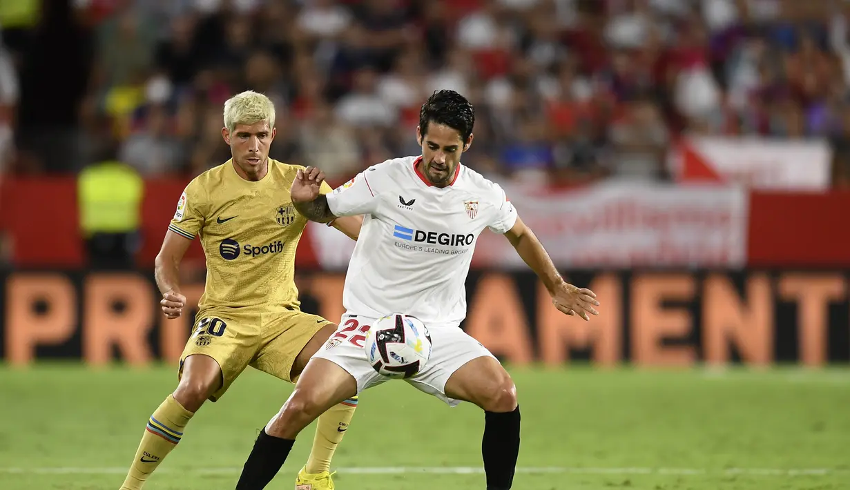 Gelandang Sevilla, Isco mengontrol bola dari kawalan bek Barcelona, Sergi Roberto selama pertandingan lanjutan La Liga Spanyol di Seville, Spanyol, Sabtu (3/9/2022). Barcelona menang telak atas Sevilla 3-0. (AP Photo/Jose Breton)