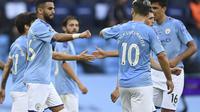 Gelandang sayap Manchester City Riyad Mahrez diberi selamat oleh rekan setimnya usai mencetak gol ke gawang Burnley pada pekan ke-30 Liga Inggris di Etihad Stadium, Selasa (23/6/2020) dini hari WIB. (AP Photo / Shaun Botterill, Pool)