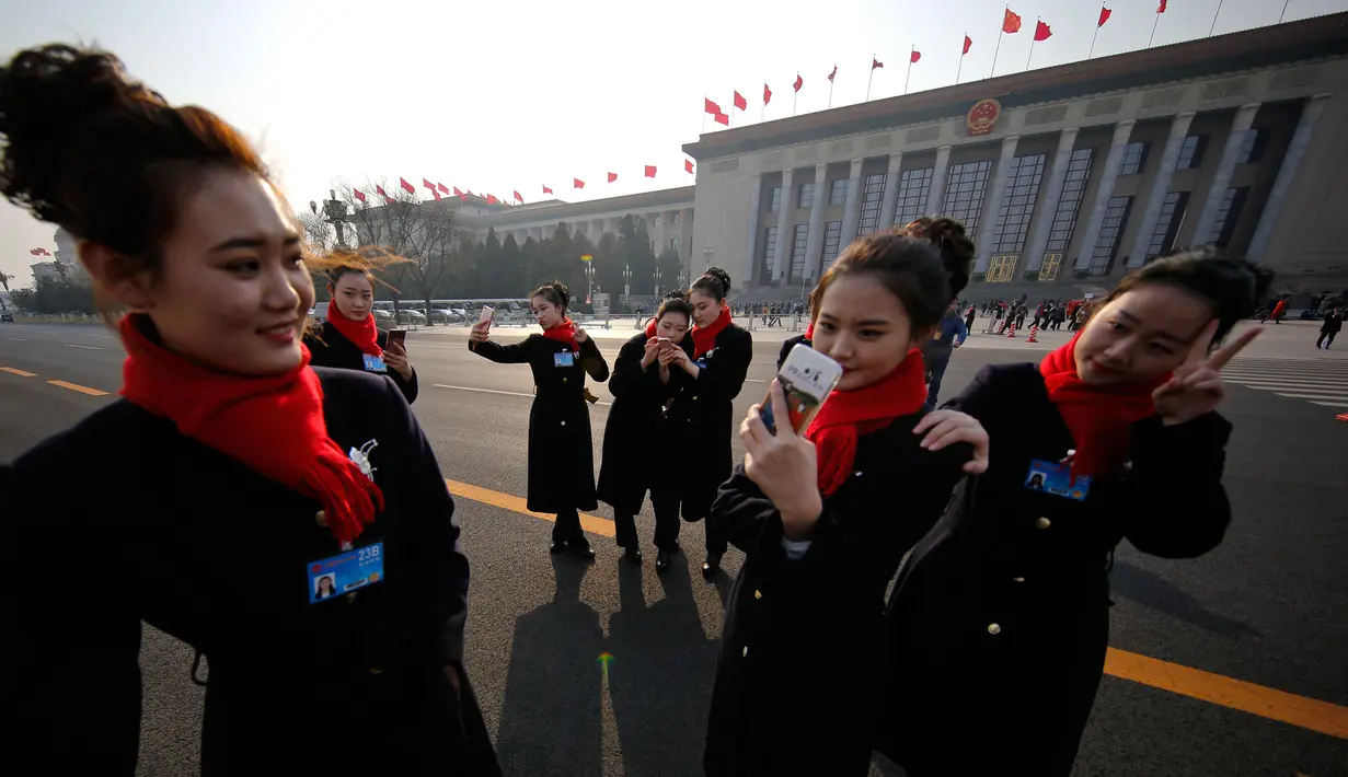 Pemandu bus wanita berfoto narsis di dekat Balai Besar Rakyat selama Konferensi Konsultatif Politik Rakyat Cina (CPPCC) di Beijing, (3/3). Ribuan delegasi telah berkumpul di untuk pembukaan sidang tahunan Rakyat Cina. (AP Photo/Andy Wong)