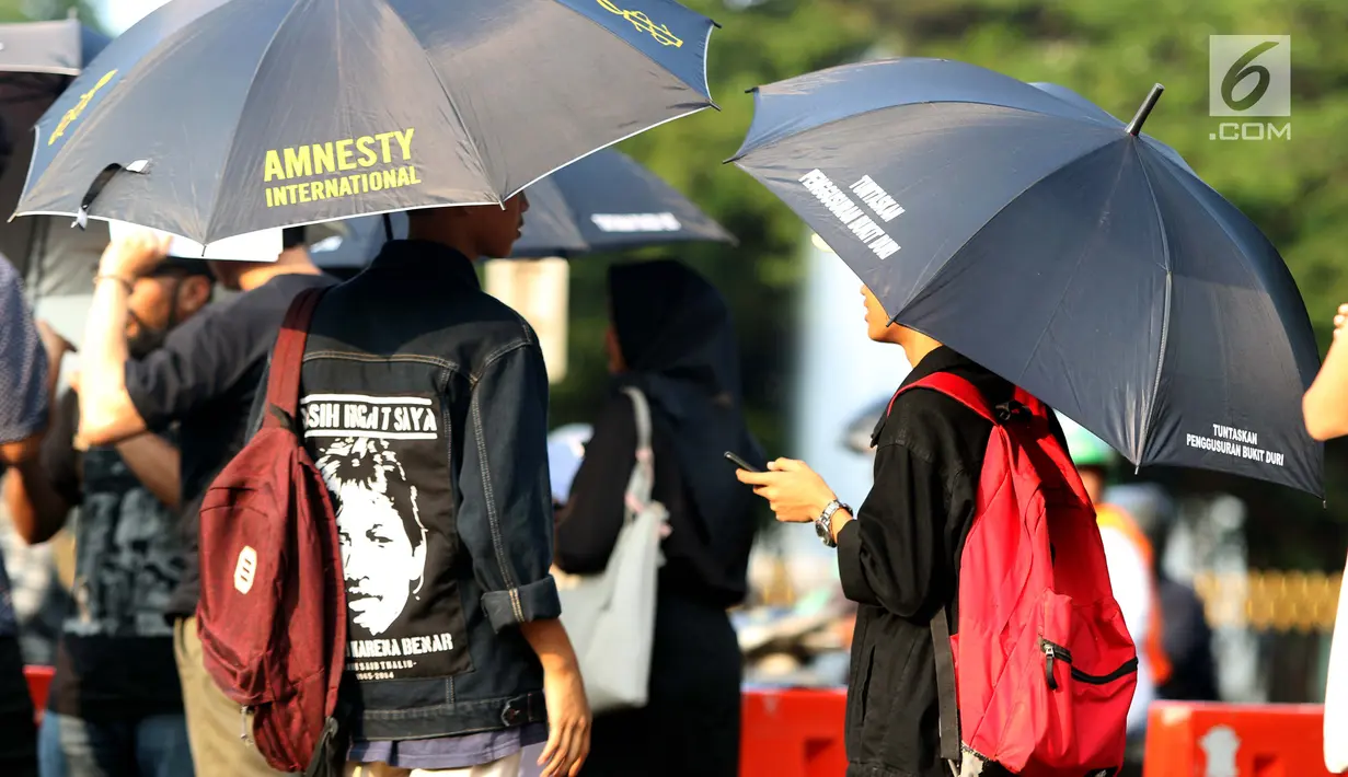 Peserta aksi Kamisan saat aksi di kawasan Silang Monas depan Istana Negara, Jakarta, Kamis (14/2). Seiring aksi Kamisan, JSKK meminta komitmen pemerintah untuk menyelesaikan kasus pelanggaran HAM masa lalu. (Liputan6.com/Helmi Fithriansyah)
