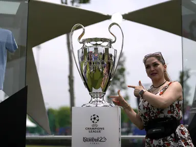 Seorang pengunjung perempuan berfoto dengan trofi Liga Champions di Istanbul, Turki, Kamis (8/6/2023). Laga final yang mempertemukan Inter Milan melawan Manchester City akan berlangsung di Atatürk Olympic Stadium, Istanbul, Turki, Minggu (9/6/2023) dini hari WIB. (AP Photo/Khalil Hamra)