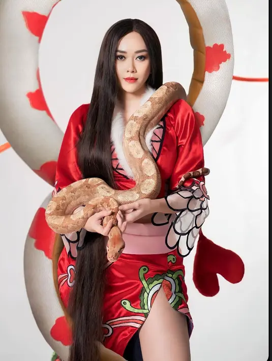 Dikenal sebagai artis yang tidak takut dengan ular, di pemotretan kali ini Aura Kasih pun turut membawa hewan melata itu. Ia memegang kepala piton berukuran besar dan menaruh badan ular itu di bahunya. Totalitasnya tersebut membuatnya disebut sebagai Boa Hancock versi Indonesia. (Liputan6.com/IG/@aurakasih)
