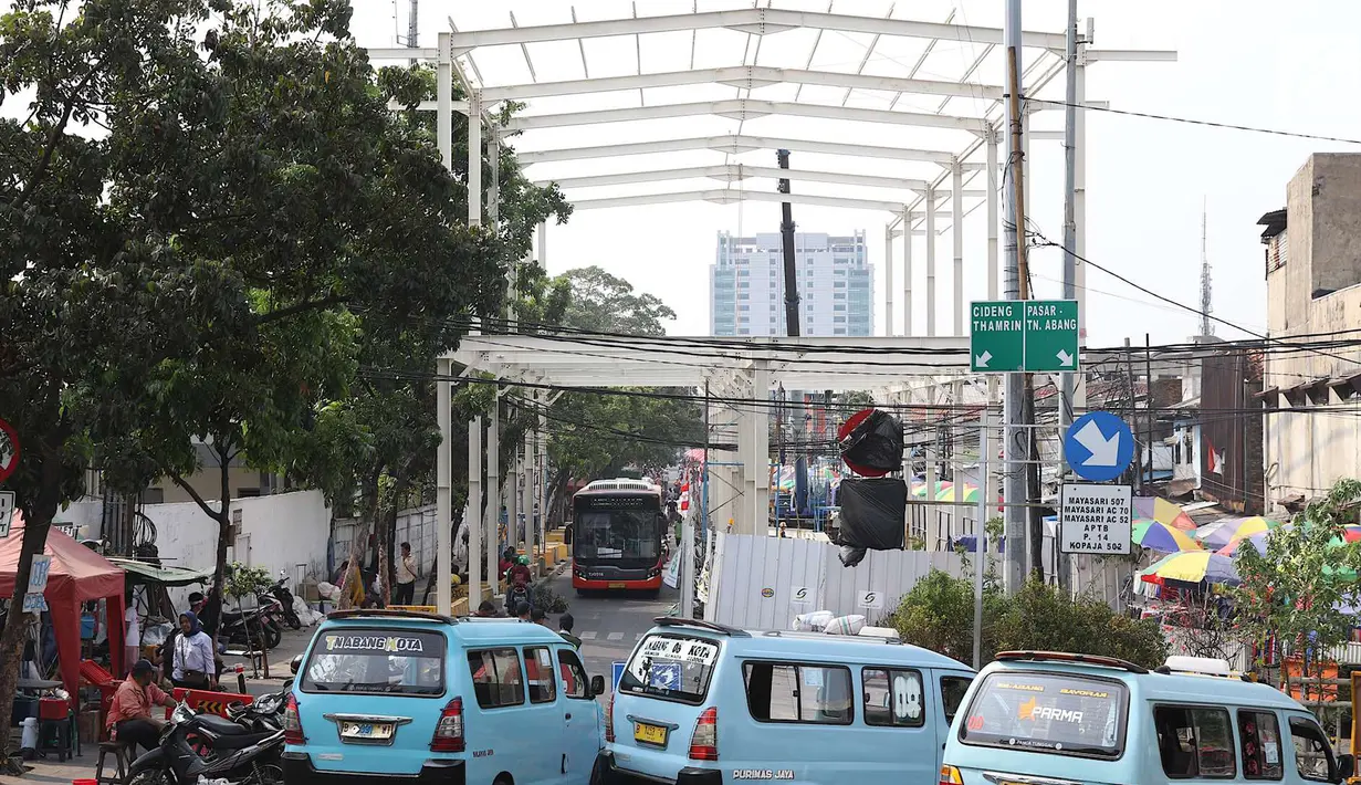 Bus Transjakarta melintas dekat proyek pembangunan Jembatan Penyeberangan Multiguna atau Skybridge di Tanah Abang, Jakarta, Jumat (24/8). Pembangunan jembatan tersebut ditargetkan selesai pada Oktober 2018. (Liputan6.com/Immanuel Antonius)