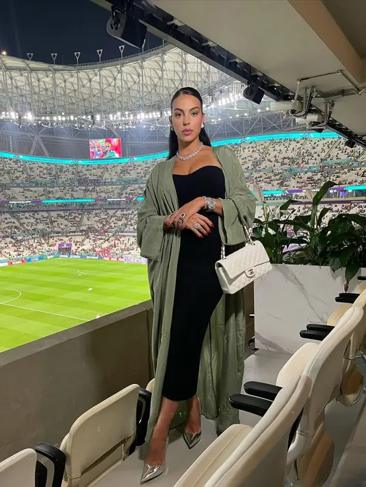 Menyaksikan World Cup 2022, Georgina memilih tampil ala sosiala dengan dress. Bahkan ia mengenakan heels silver dan outer sage [@georginagio]