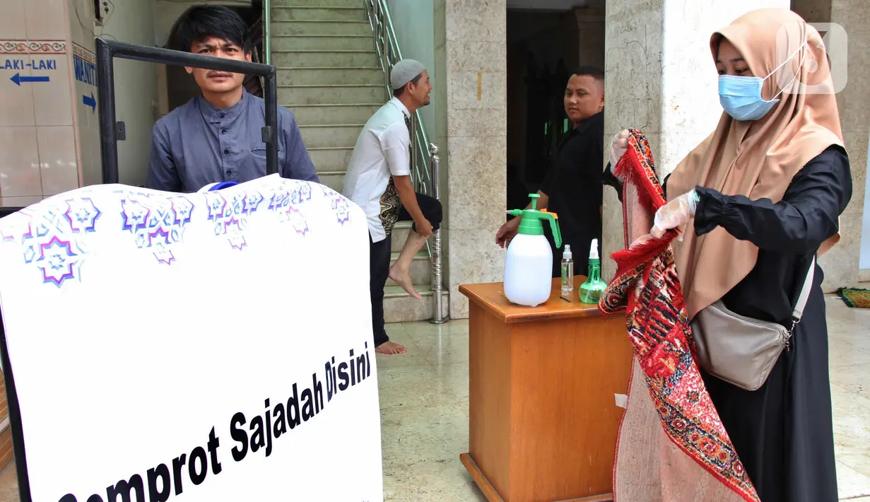 Petugas menyemprotkan cairan disinfektan ke sajadah jemaah sebelum Salat Jumat di Masjid El-Syifa, Jakarta, Jumat (20/3/2020). MUI telah mengeluarkan Fatwa MUI Nomor 14 Tahun 2020 tentang Penyelenggaraan Ibadah dalam Situasi Terjadi Wabah COVID-19. (Liputan6.com/Fery Pradolo)