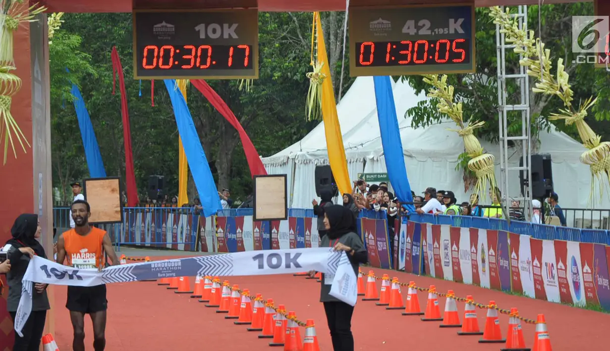 Peserta berhasil memasuki garis finish saat mengikuti Borobudur Marathon 2018 di Pelataran Taman Lumbini Borobudur Magelang, Minggu (18/11). Borobudur Marathon 2018 diikuti oleh 9. 672 pelari. (Liputan6.com/Gholib)