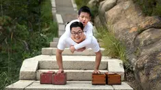 Dua orang asal Tiongkok, Gao Zhiyu (atas) dan Chen Zhou berpose di tengah perjalanannya mendaki gunung di Qingdao, Tiongkok, Selasa (13/9). Keduanya tak memiliki kaki dan menggunakan balok kayu untuk mendaki gunung setinggi 1130 meter. (REUTERS)