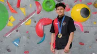 Atlet panjat tebing Indonesia, Veddriq Leonardo berfoto dengan medali emas Olimpiade Paris 2024 di markas FPTI, Hotel Santika Premier, Bekasi, Selasa (20/08/2024). (Bola.com/Bagaskara Lazuardi)