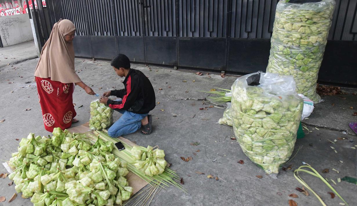 Peningkatan produksi ini menjadi bagian kebutuhan bahan pelengkap hidangan khas lebaran. Tampak dalam foto, pedagang menyelesaikan produksi kulit ketupat lebaran di Pasar Pondok Labu, Jakarta, Rabu (18/3/2026). (merdeka.com/Arie Basuki)