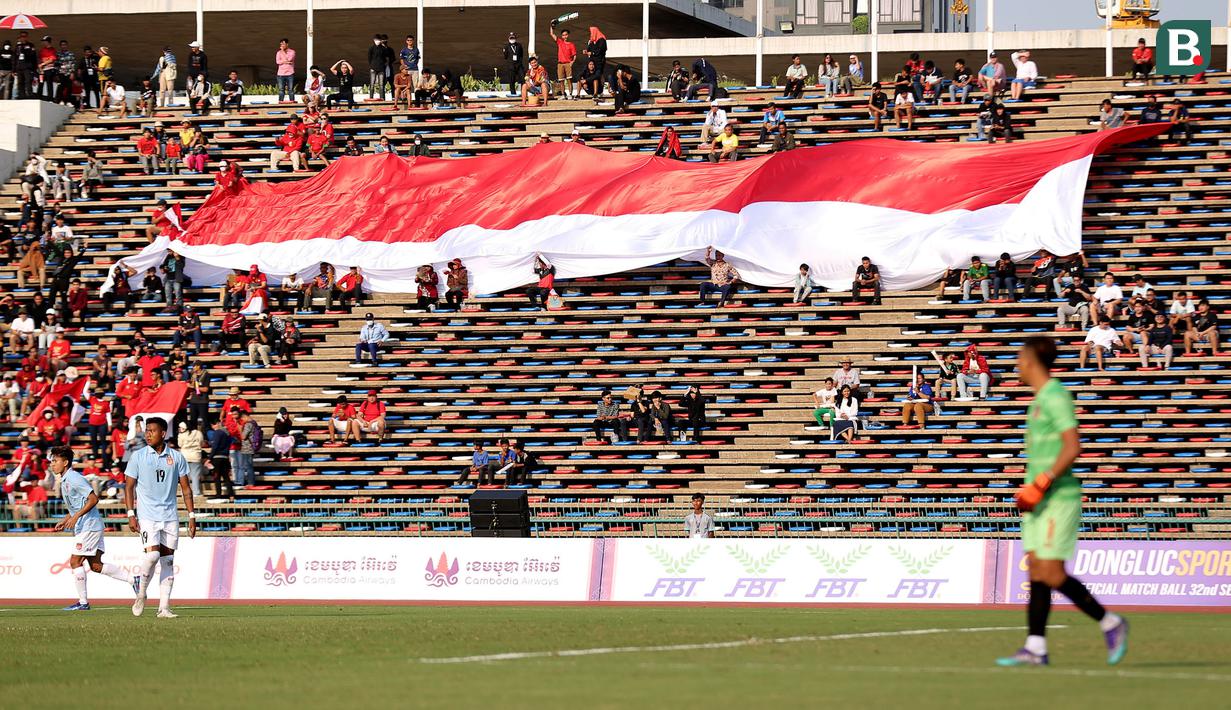 Pendukung Indonesia membentangkan bendera Merah Putih raksasa saat laga kedua Grup A Sepak Bola SEA Games 2023 antara Timnas Indonesia melawan Timnas Myanmar di Olympic Stadium, Phnom Penh, Kamboja, Kamis (04/05/2023). Skuad asuhan Indra Sjafri tersebut berhasil menang dengan skor telak 5-0. (Bola.com/Abdul Aziz)