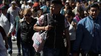 Seorang pria menggunakan tas kain untuk membawa belanjaannya di Mexico City, Rabu, 1 Januari 2020. (Source: AP)