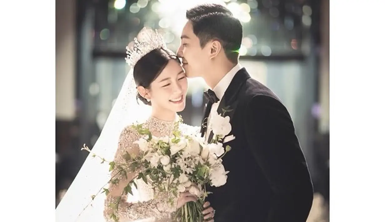 Foto pertama saat di altar pernikahan, Lee Seung Gi tampil dengan setelan jas hitam sementara Lee Da In mengenakan long sleeve wedding dress lengkap dengan tiara dan veil. [Foto: IG/byhumanmade].