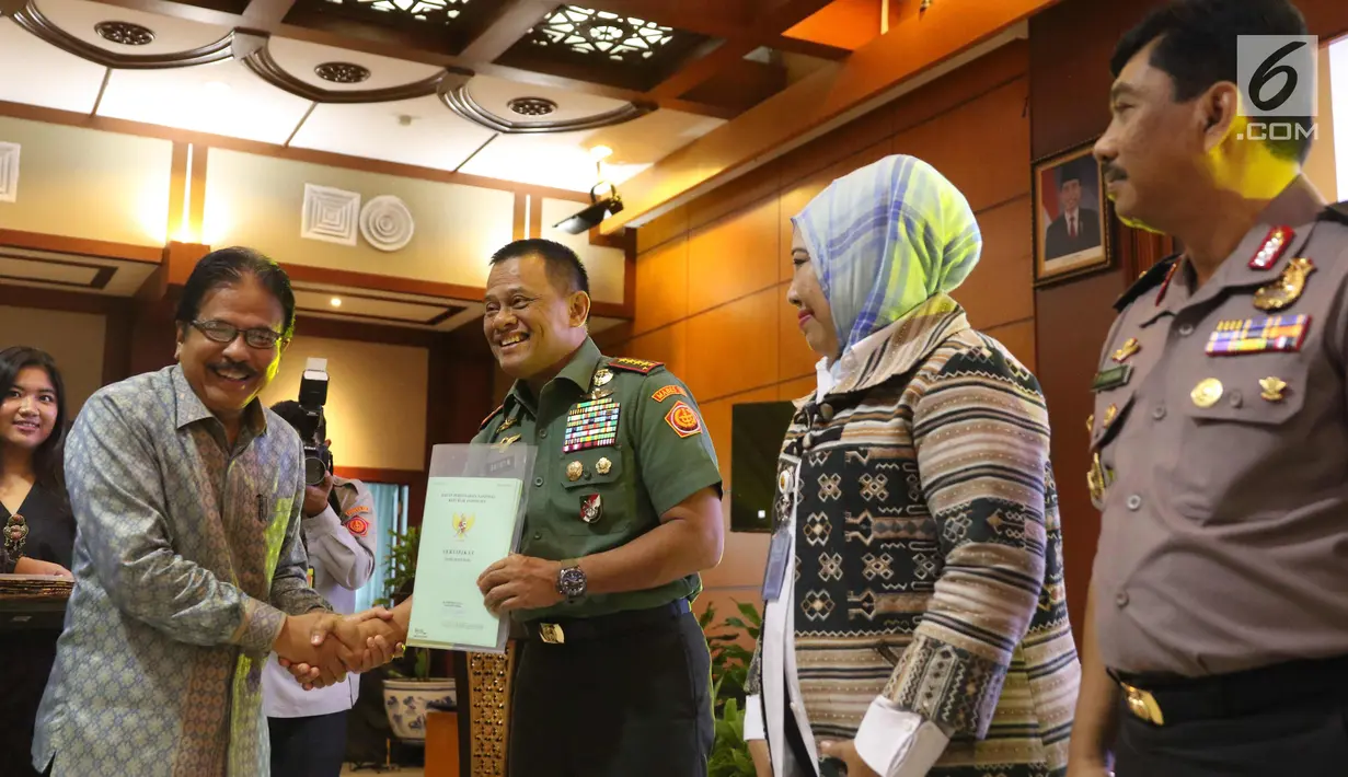 Menteri Agraria dan Tata Ruang Sofyan Djalil (kiri) memberikan sertifikat pendayagunaan tanah terlantar kepada Panglima TNI Jendral Gatot Nurmantyo dalam acara Hari Tata Ruang Nasional 2017 di Jakarta, Selasa (14/11). (Liputan6.com/Angga Yuniar)